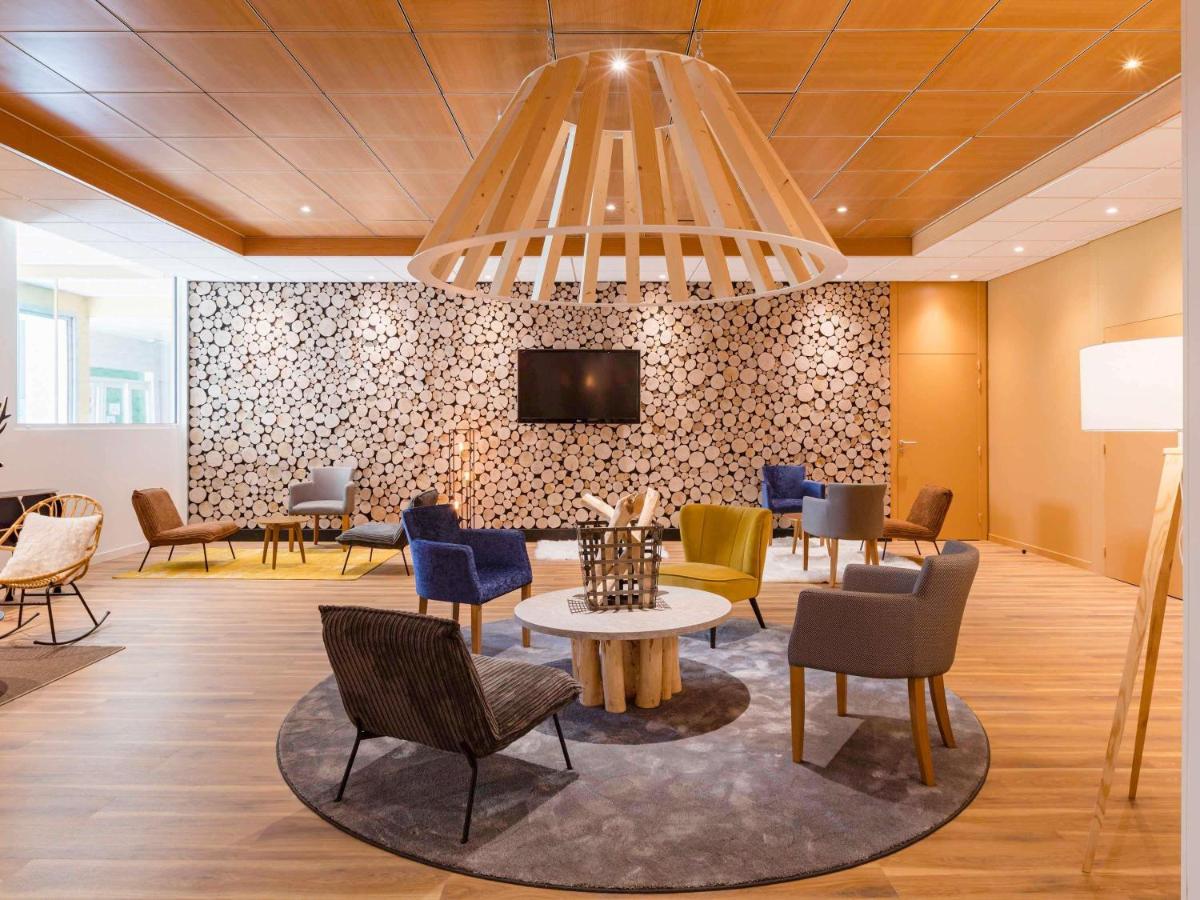 un hall avec des chaises, une table et une télévision dans l'établissement ibis Styles Aix les Bains Domaine de Marlioz, à Aix-les-Bains