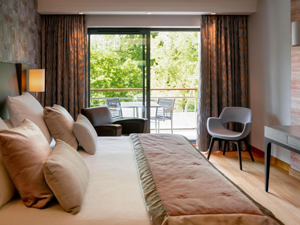 une chambre avec un grand lit et un balcon dans l'établissement Parc Beaumont Hôtel & Spa Pau - MGallery Collection, à Pau