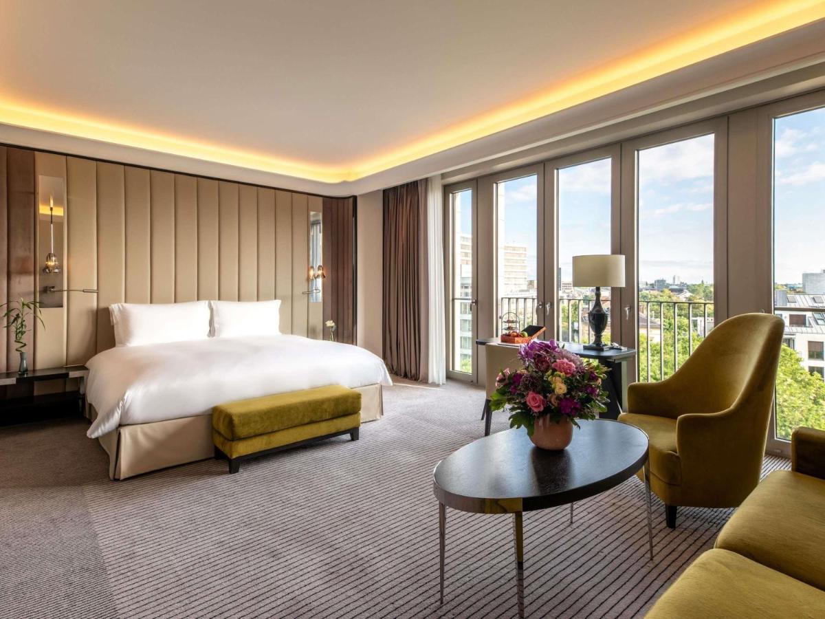 ein Hotelzimmer mit einem Bett und einer Couch in der Unterkunft Sofitel Frankfurt Opera in Frankfurt am Main + 217 Fotos