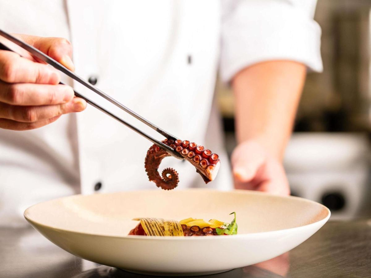 Eine Person, die mit Stäbchen eine Schüssel Essen isst. in der Unterkunft Sofitel Frankfurt Opera in Frankfurt am Main