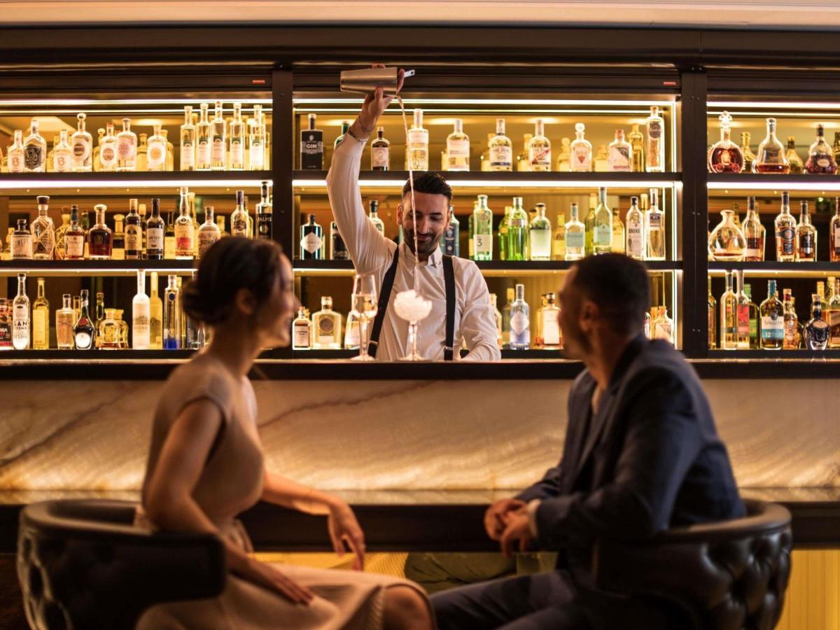 zwei Frauen und ein Barkeeper in einer Bar in der Unterkunft Sofitel Frankfurt Opera in Frankfurt am Main