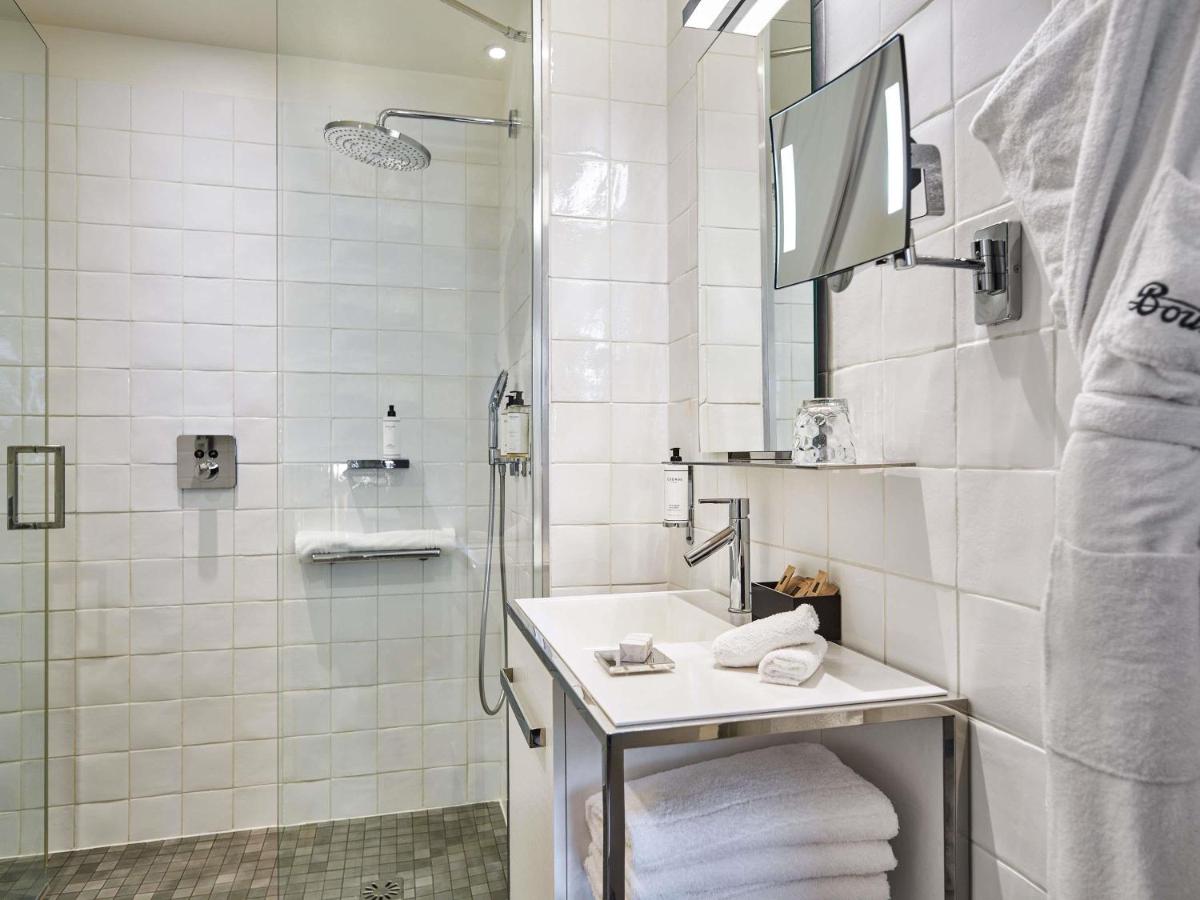 une salle de bain blanche avec lavabo et douche dans l'établissement Boutet Bastille Hotel Paris - MGallery Collection, à Paris