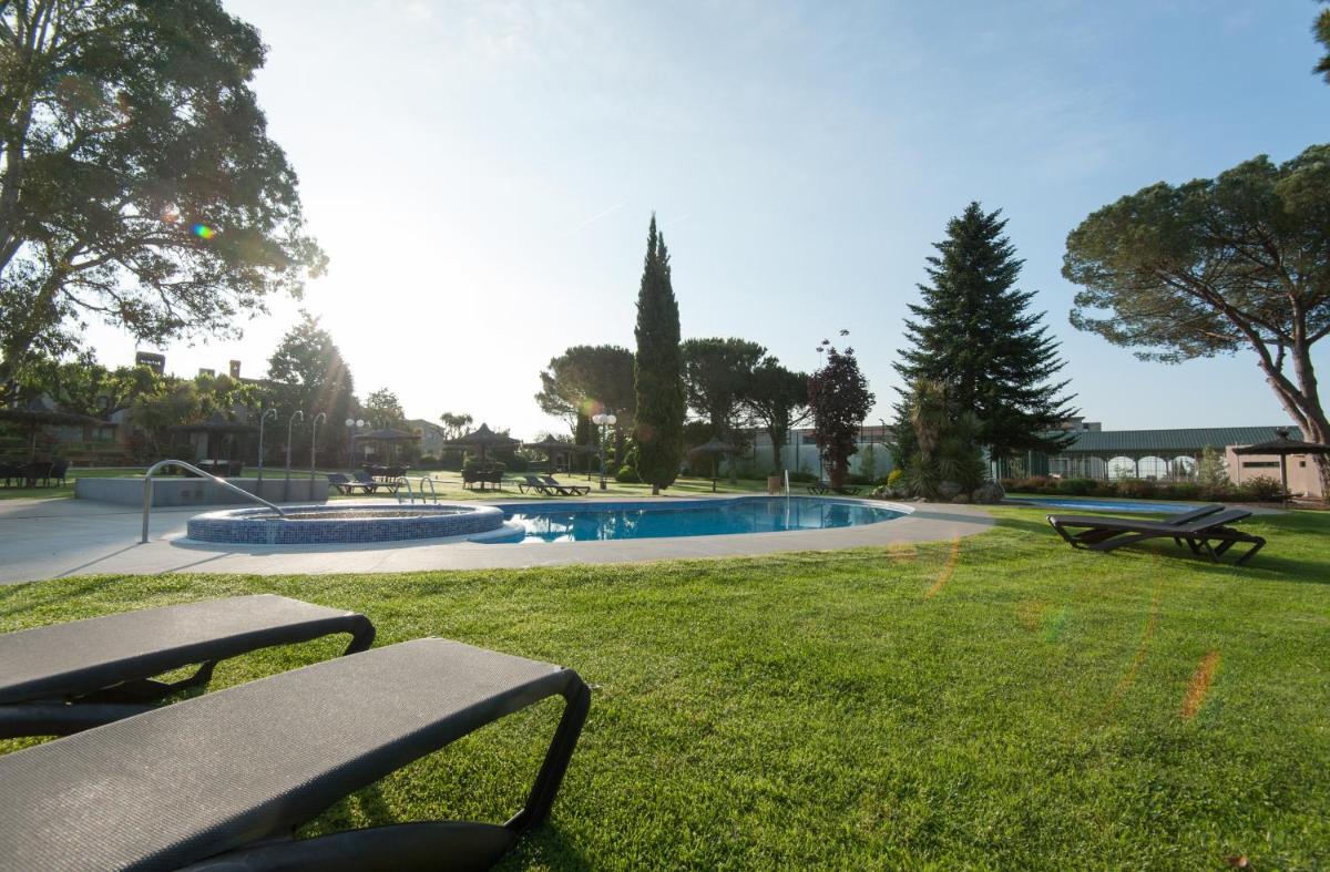un parque con banco y piscina en Hotel Mas Solà, en Santa Coloma de Farners