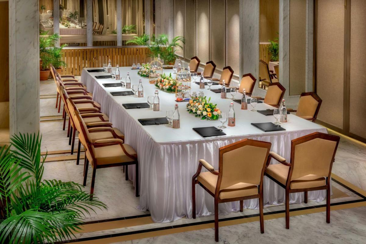 a long table in a room with chairs at ITC Kakatiya, a Luxury Collection Hotel, Hyderabad in Hyderabad