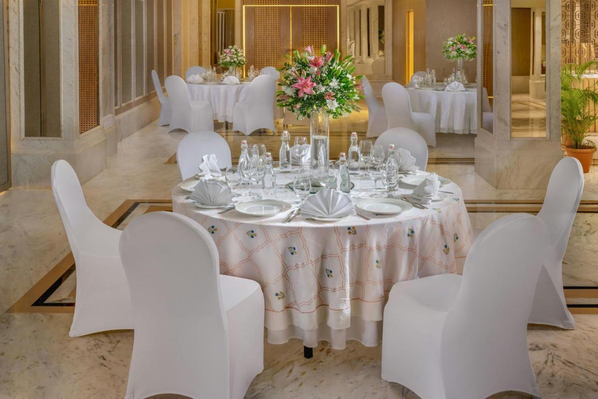 a dining room with white tables and white chairs at ITC Kakatiya, a Luxury Collection Hotel, Hyderabad in Hyderabad