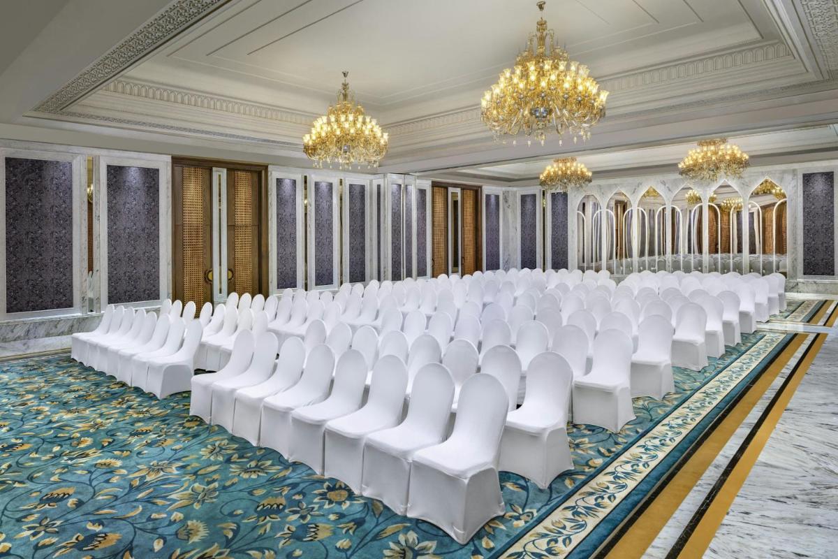 a row of white chairs in a room with chandeliers at ITC Kakatiya, a Luxury Collection Hotel, Hyderabad in Hyderabad