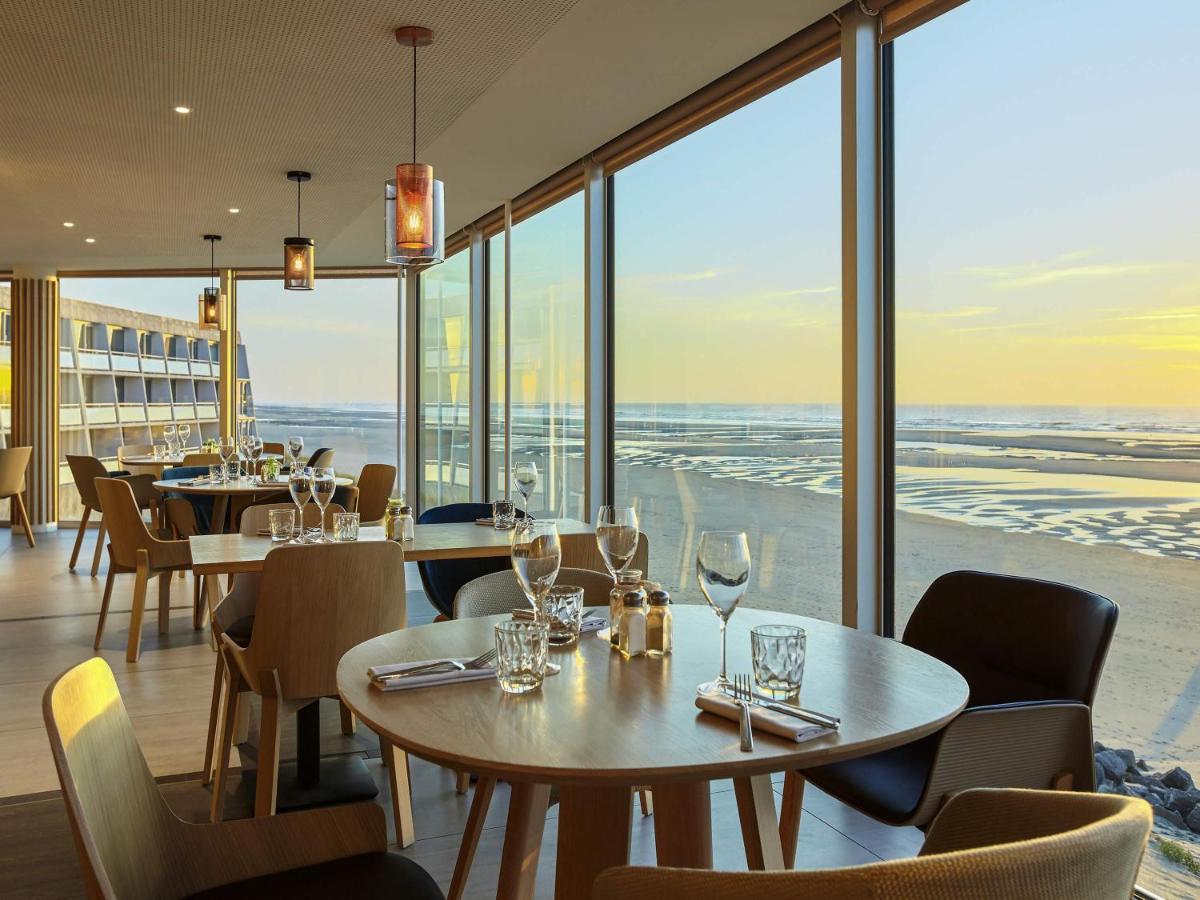 un restaurant avec des tables et des chaises et une vue sur l'océan dans l'établissement Novotel Thalassa Le Touquet, à Le Touquet-Paris-Plage