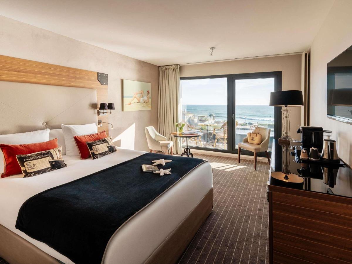 une chambre d'hôtel avec un grand lit et une grande fenêtre dans l'établissement Côte Ouest Thalasso & Spa Les Sables d'Olonne - MGallery Collection, à Les Sables-dʼOlonne