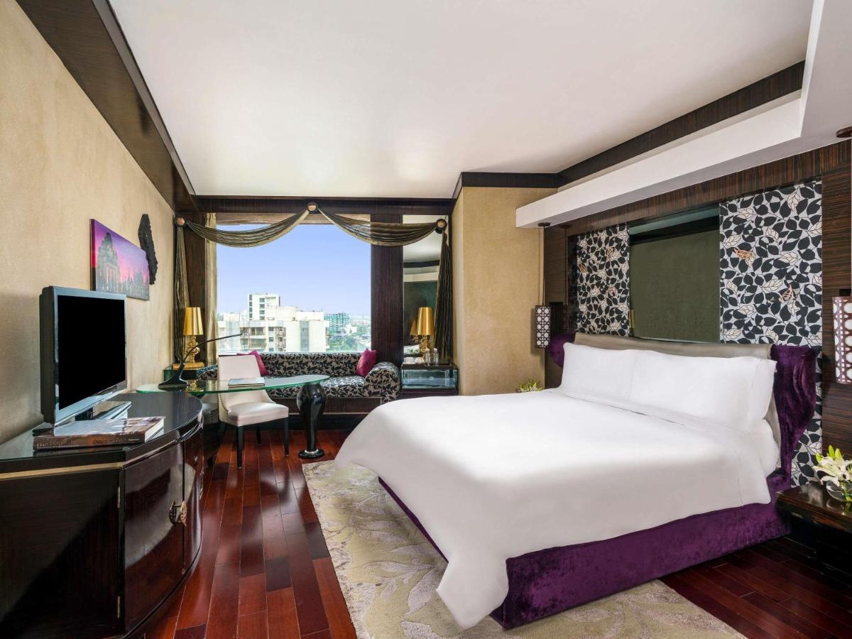 a bedroom with a large white bed and a television at Sofitel Mumbai BKC in Mumbai a bedroom with a large white bed and a television at Sofitel Mumbai BKC in Mumbai