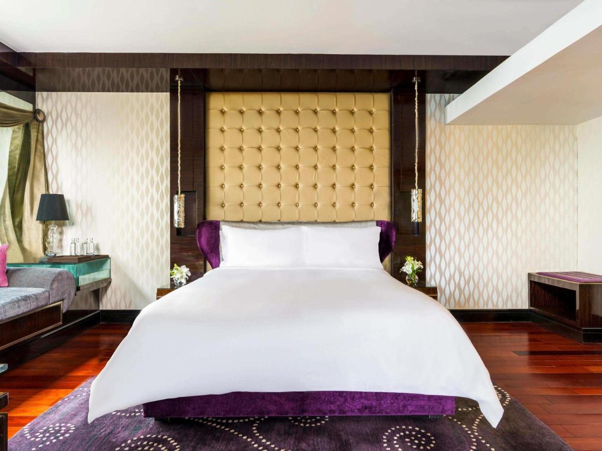 a bedroom with a large bed and a couch at Sofitel Mumbai BKC in Mumbai