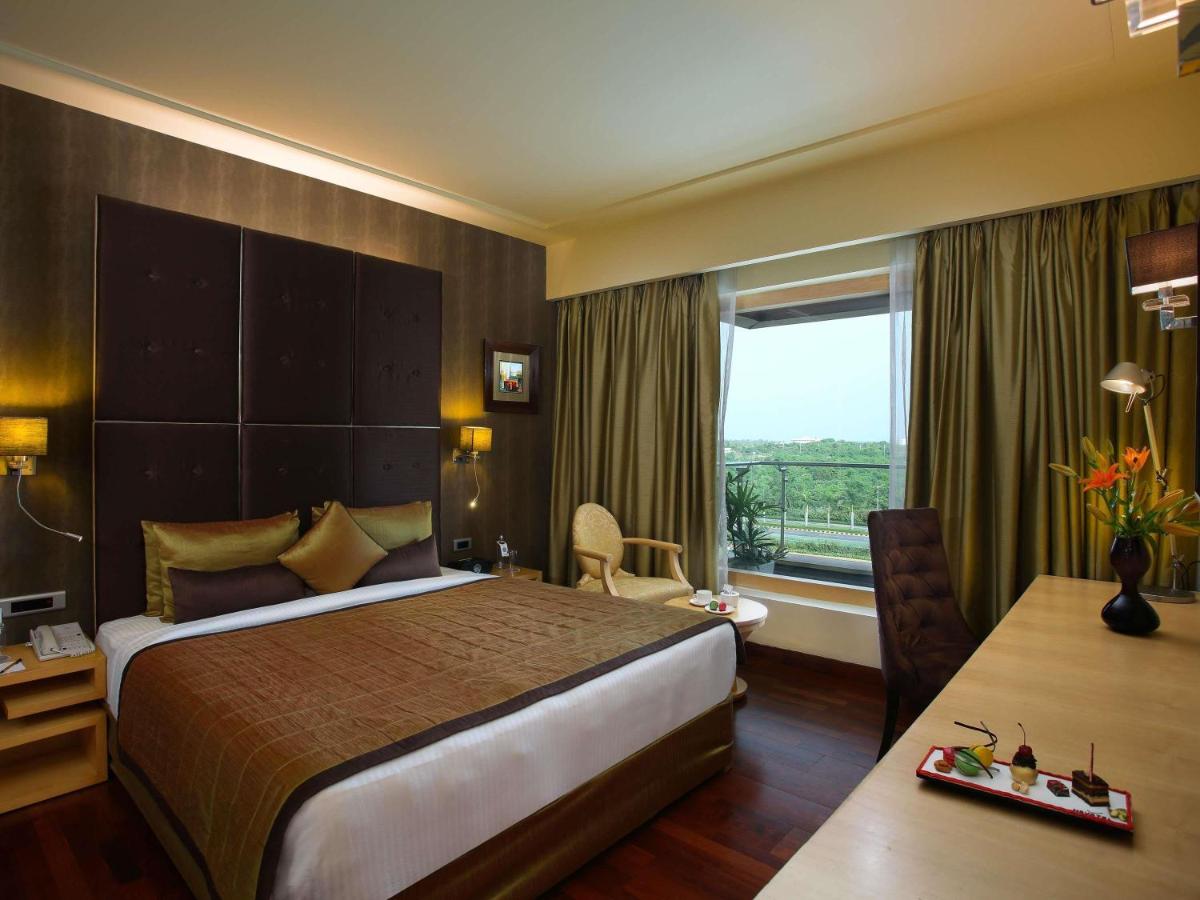 a hotel room with a large bed and a window at Novotel Hyderabad Airport in Hyderabad