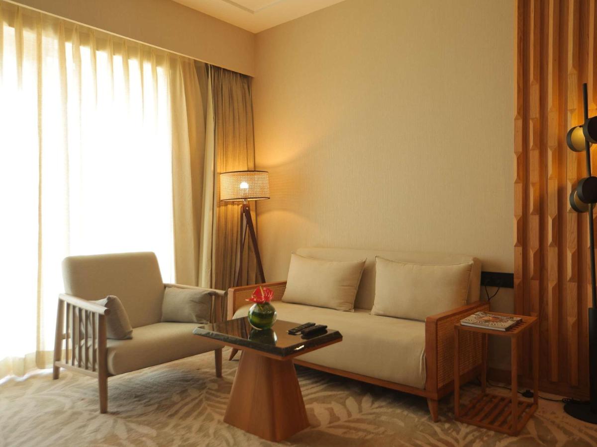 a living room with a couch and a table at Novotel Hyderabad Airport in Hyderabad