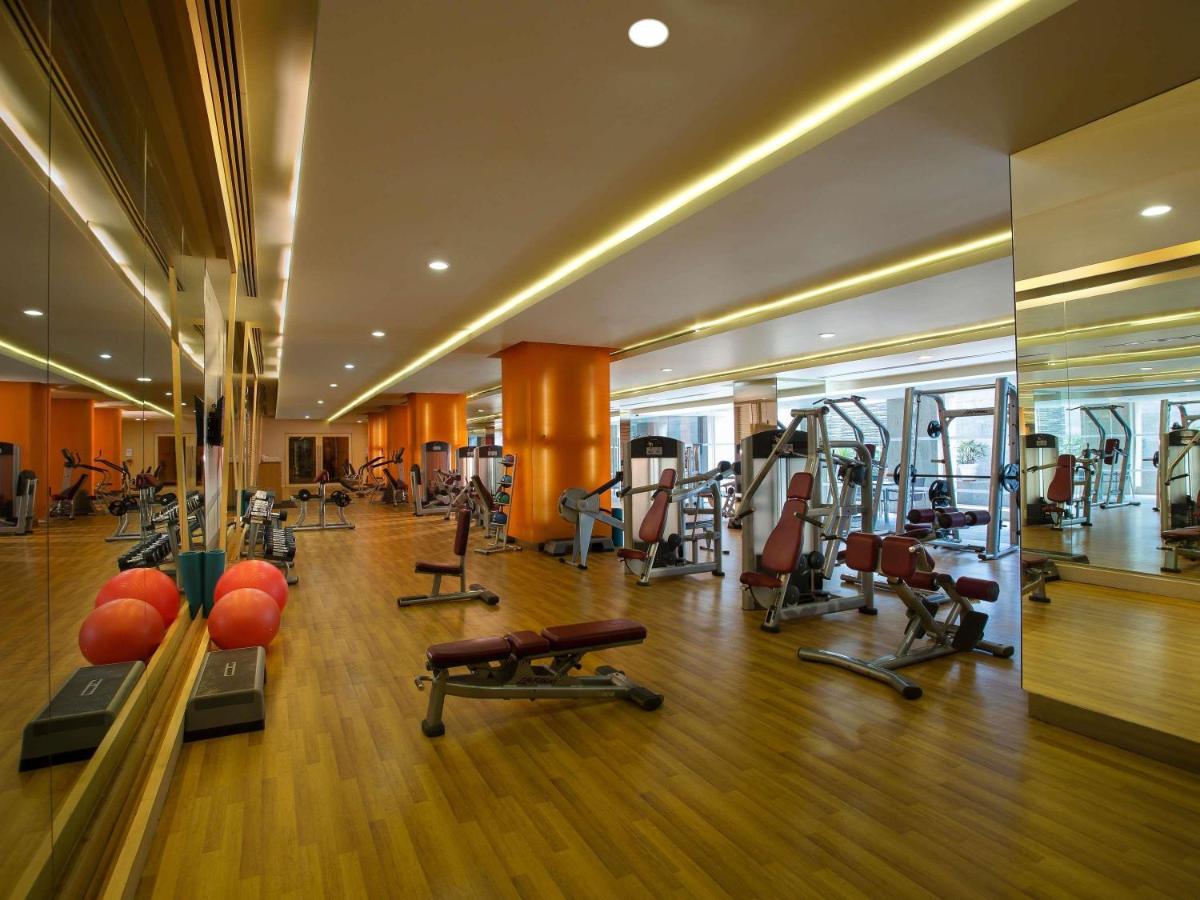 a gym with treadmills and exercise equipment in a building at Novotel Hyderabad Airport in Hyderabad a gym with treadmills and exercise equipment in a building at Novotel Hyderabad Airport in Hyderabad