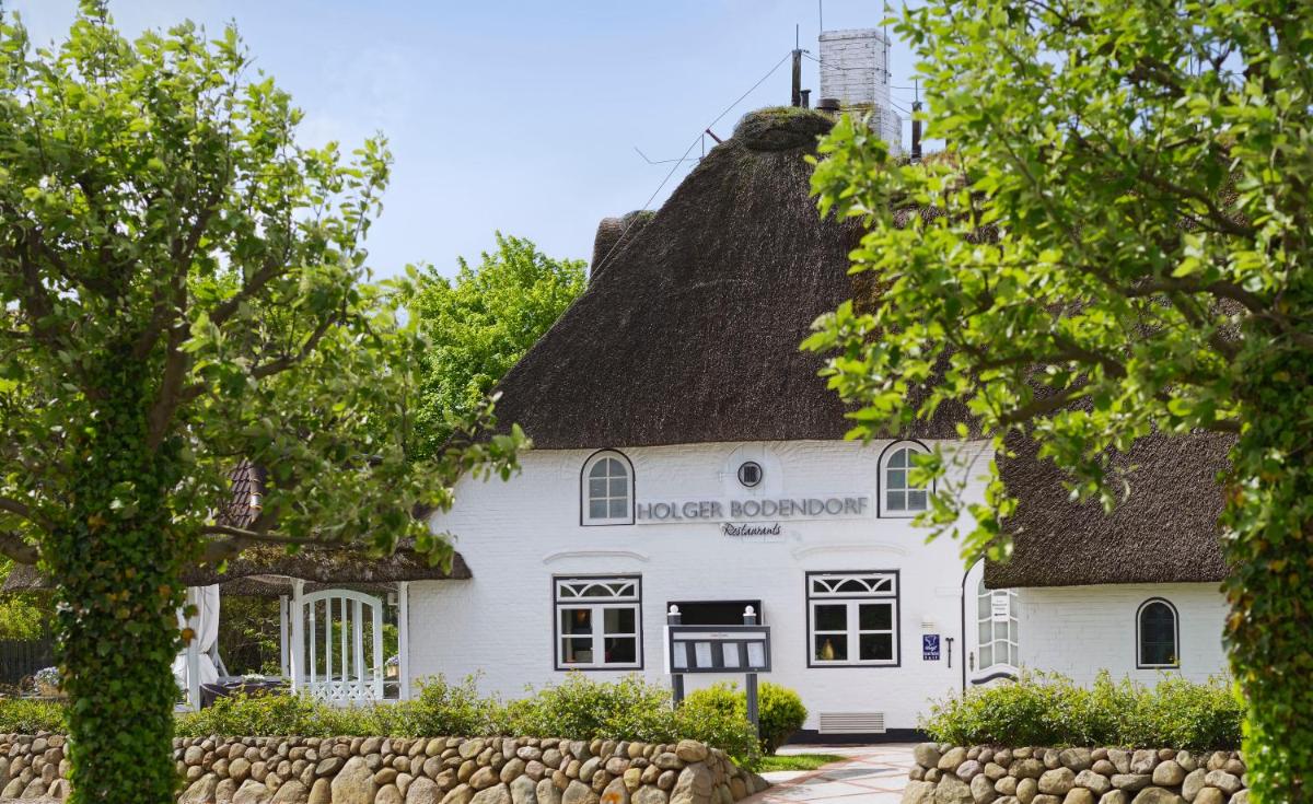 ein weißes Haus mit einem Strohdach in der Unterkunft Relais & Châteaux Landhaus Stricker in Tinnum ein weißes Haus mit einem Strohdach in der Unterkunft Relais & Châteaux Landhaus Stricker in Tinnum