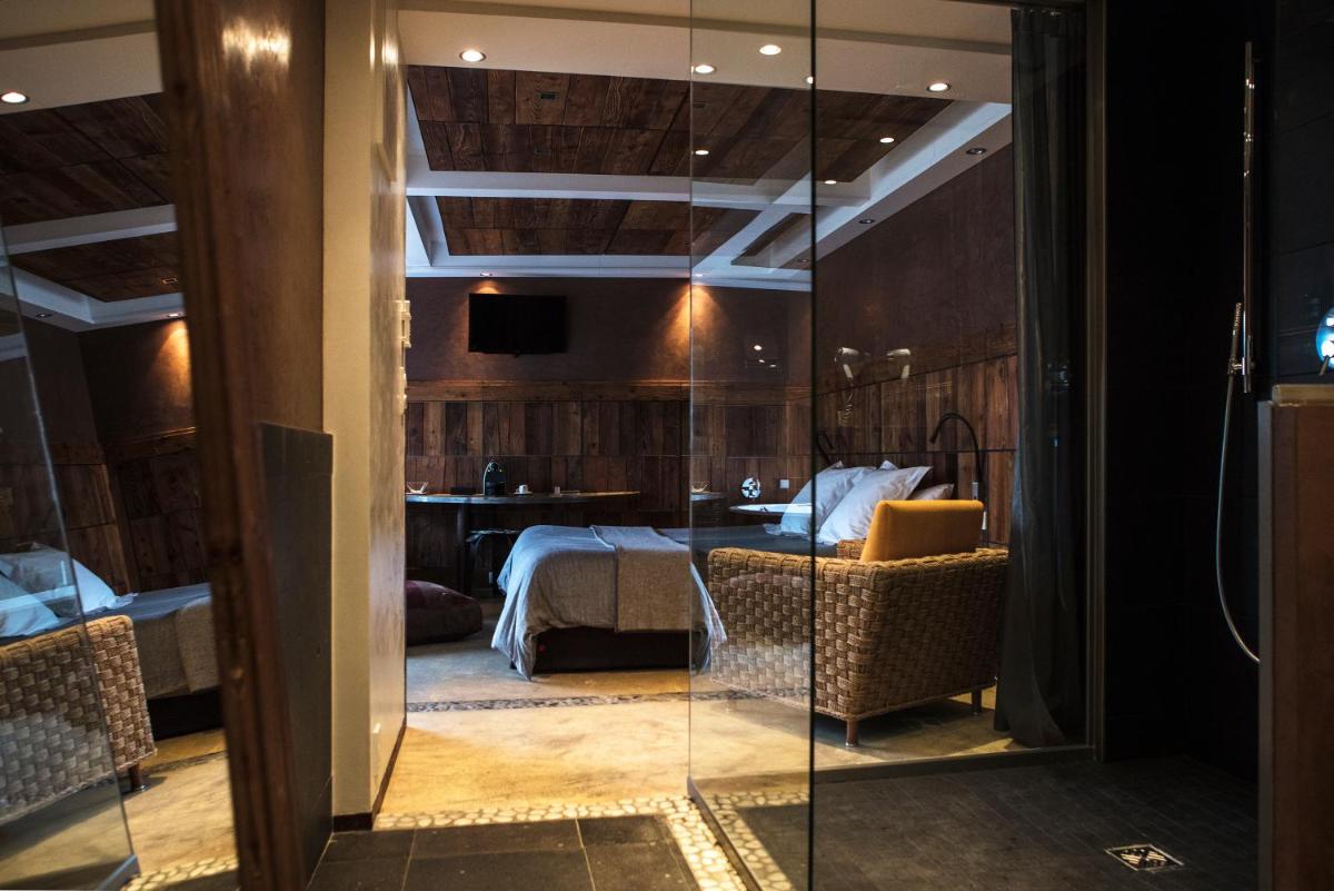 une chambre avec un lit et une porte vitrée dans l'établissement Le Clos Des Sens, à Annecy