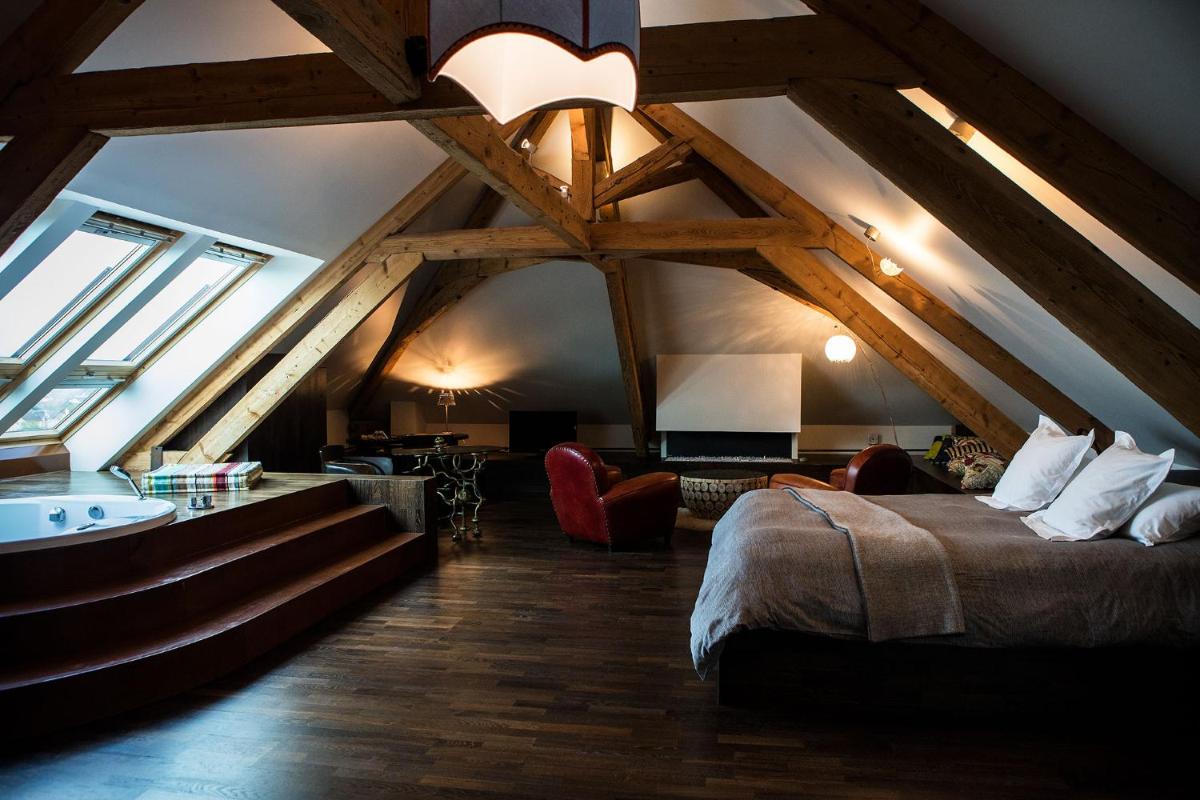 une chambre avec un lit et un lavabo dans un grenier dans l'établissement Le Clos Des Sens, à Annecy 31 autres photos
