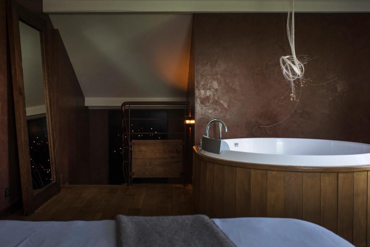 une salle de bain avec baignoire dans une chambre dans l'établissement Le Clos Des Sens, à Annecy une salle de bain avec baignoire dans une chambre dans l'établissement Le Clos Des Sens, à Annecy