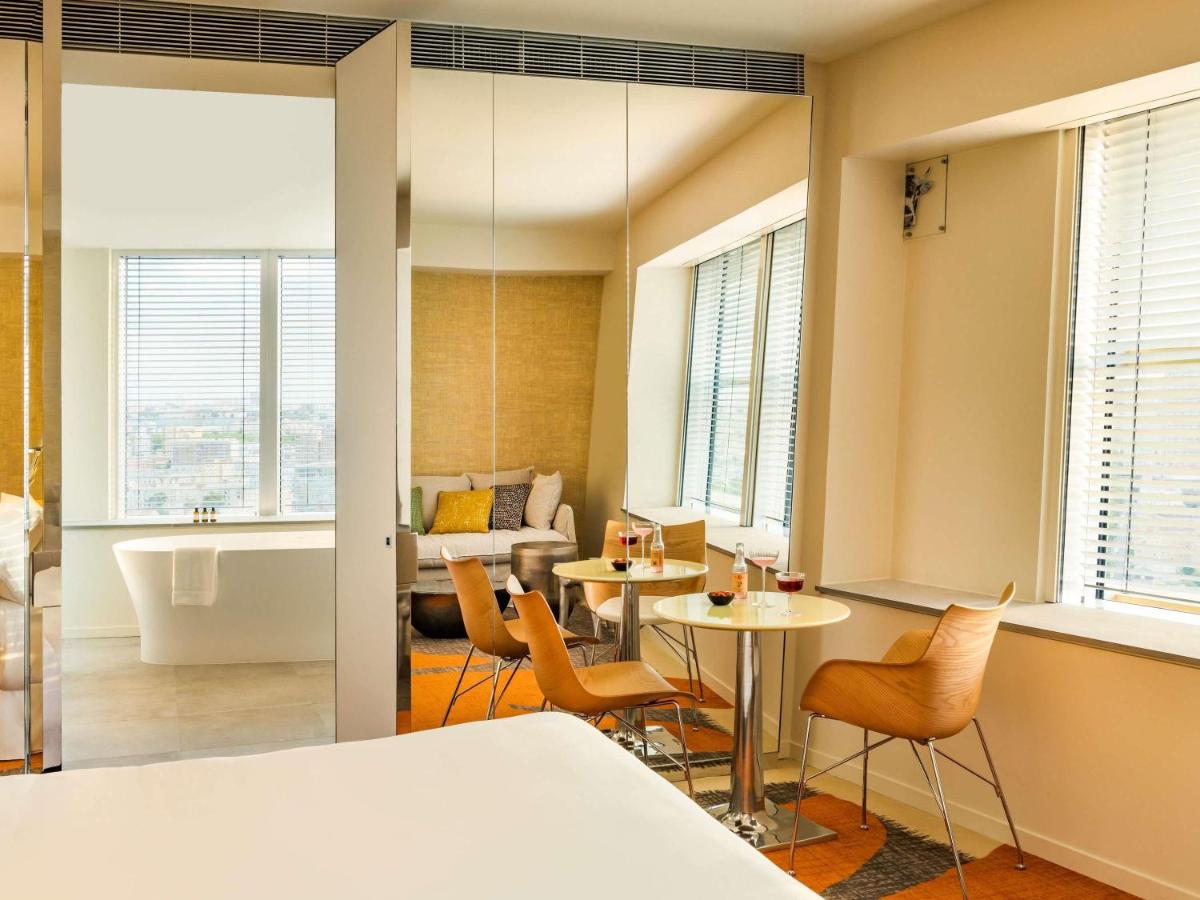 une chambre avec une baignoire, une table et des chaises dans l'établissement Too Hotel & Spa Paris - MGallery Collection, à Paris