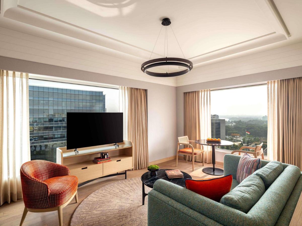 a living room with a couch and a flat screen tv at Pullman Chennai Anna Salai - Premium Brand By Accor in Chennai