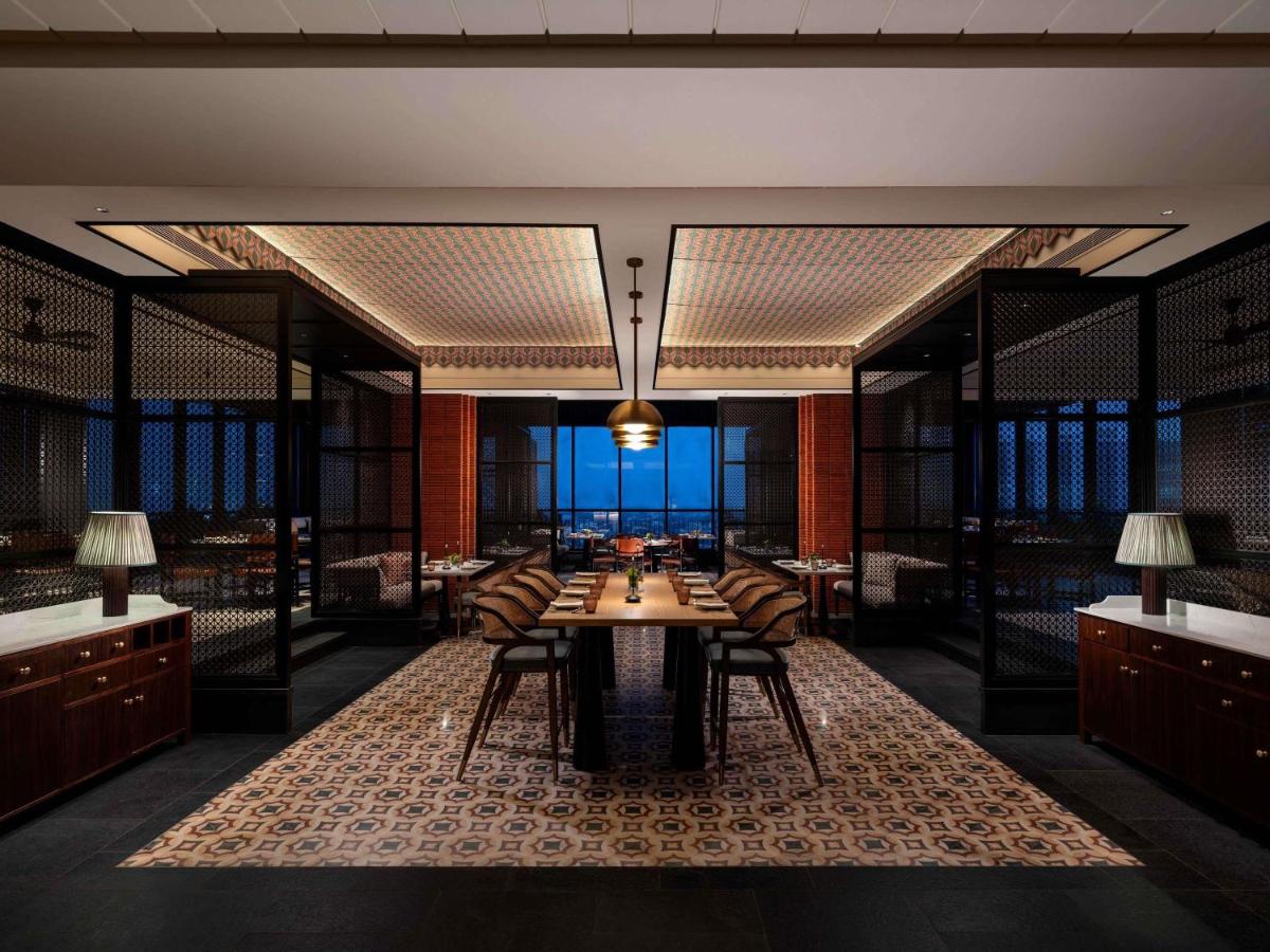 a dining room with a table and chairs at Pullman Chennai Anna Salai - Premium Brand By Accor in Chennai