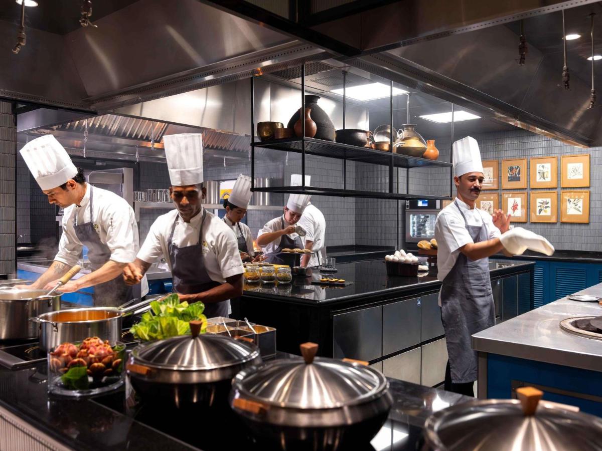 a group of chefs in a kitchen preparing food at Pullman Chennai Anna Salai - Premium Brand By Accor in Chennai
