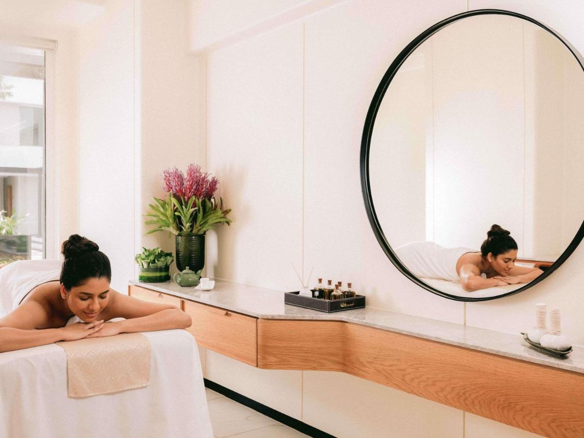 a woman laying in a bath tub in a mirror at Pullman Chennai Anna Salai - Premium Brand By Accor in Chennai