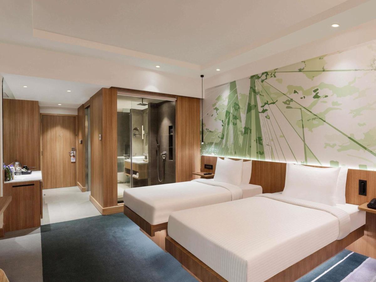 a bedroom with two beds and a painting on the wall at Novotel Mumbai Juhu Beach in Mumbai