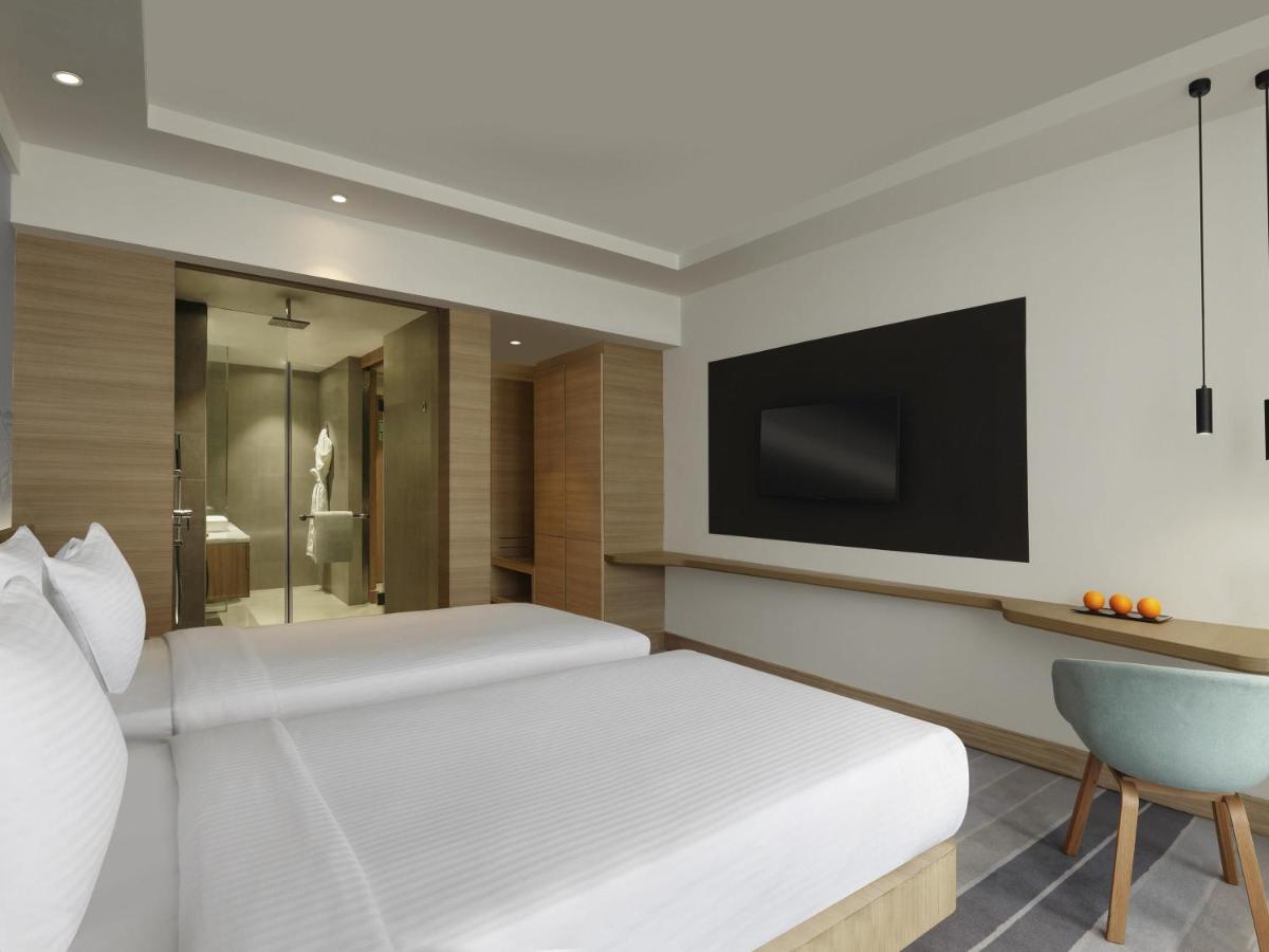 a bedroom with a large bed and a television at Novotel Mumbai Juhu Beach in Mumbai