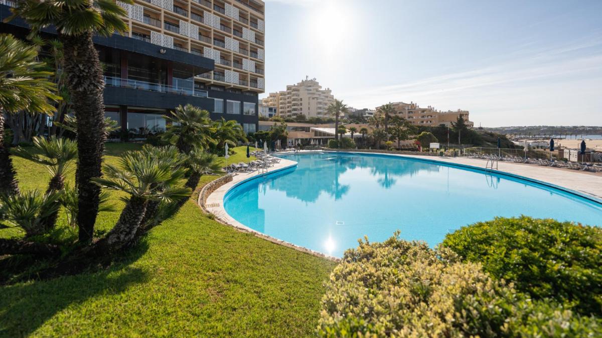uma piscina vazia com palmeiras e um prédio em Algarve Casino Hotel em Portimão mais 114 fotografias