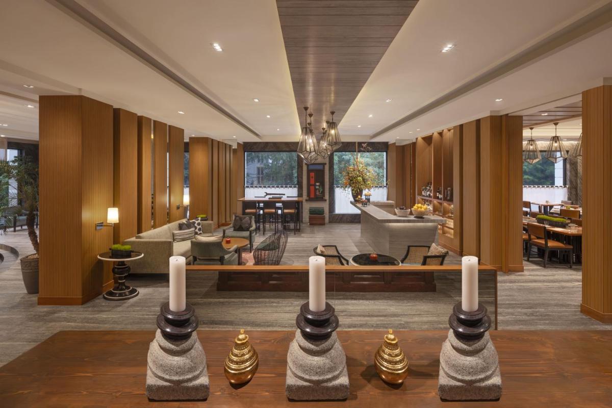 a lobby with a living room with a couch and tables at The Raintree, St. Mary’s Road in Chennai