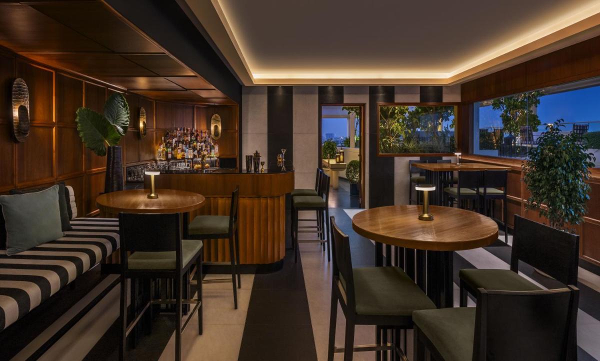 a restaurant with tables and chairs and a bar at The Raintree, St. Mary’s Road in Chennai