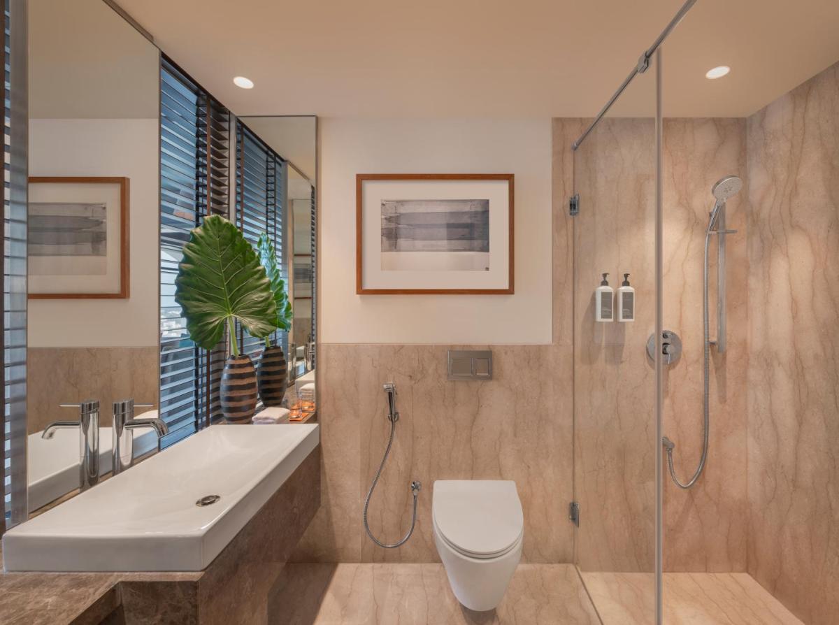 a bathroom with a shower and a toilet and a sink at The Raintree, St. Mary’s Road in Chennai