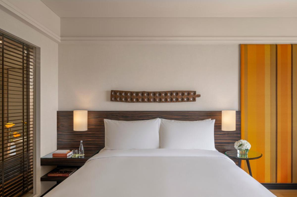 a bedroom with a large white bed and a window at The Raintree, St. Mary’s Road in Chennai