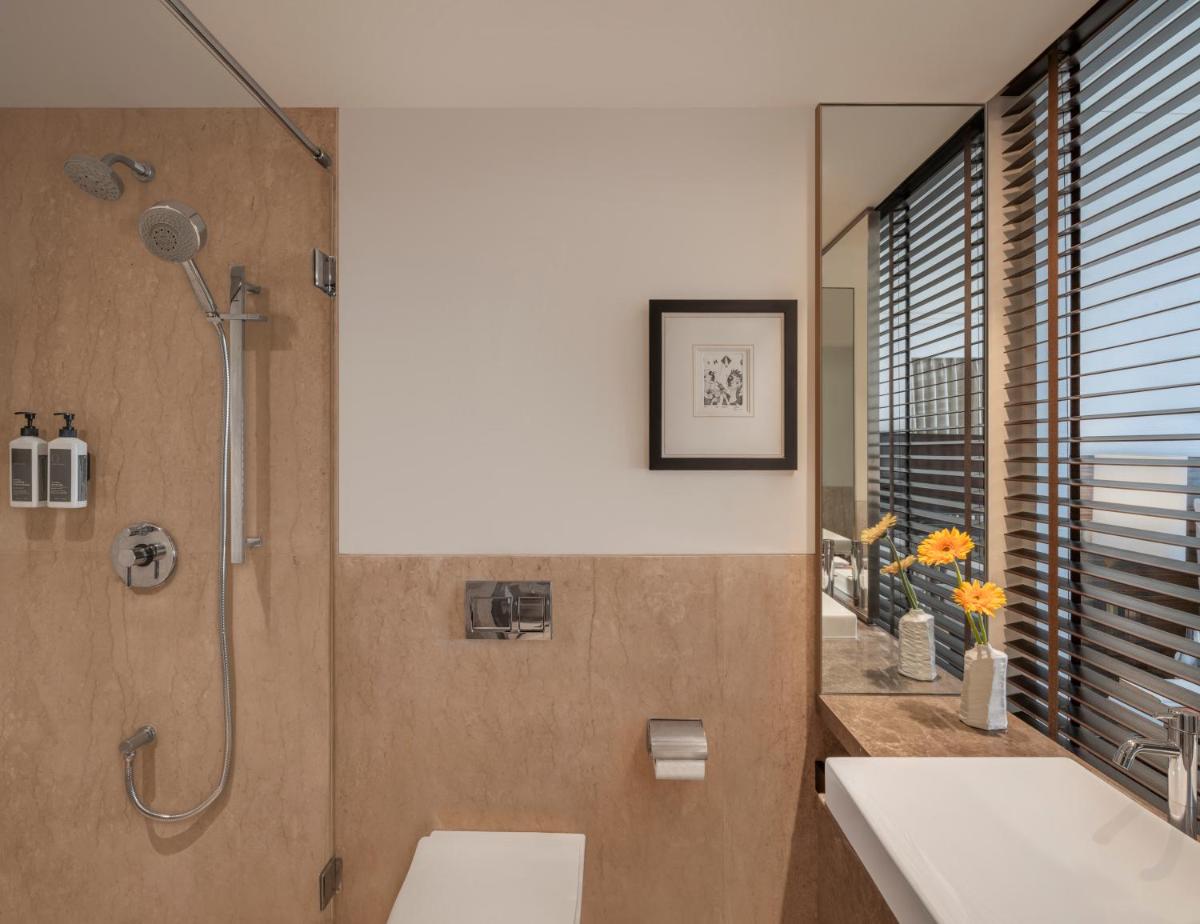 a bathroom with a shower and a sink at The Raintree, St. Mary’s Road in Chennai