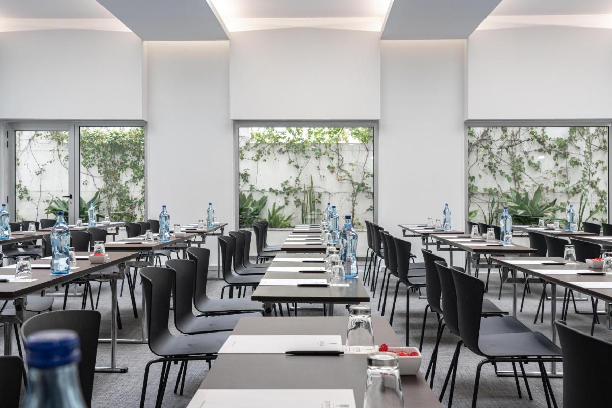 uma sala de jantar com mesas, cadeiras e janelas em Jupiter Lisboa Hotel - Rooftop & Spa em Lisboa