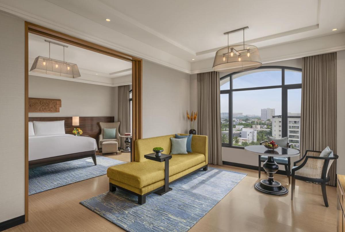 a hotel room with a bed and a couch and a table at The Raintree, St. Mary’s Road in Chennai