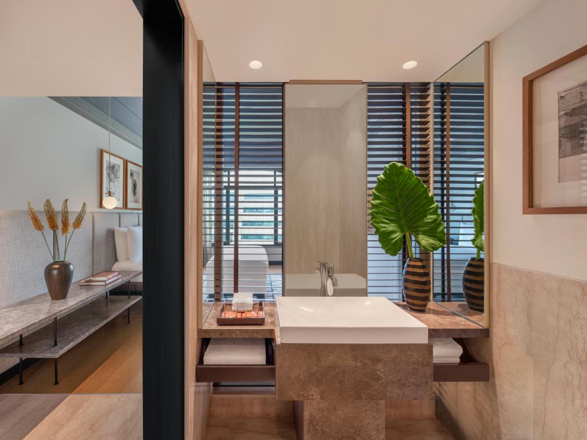 a bathroom with a sink and a mirror at The Raintree, St. Mary’s Road in Chennai