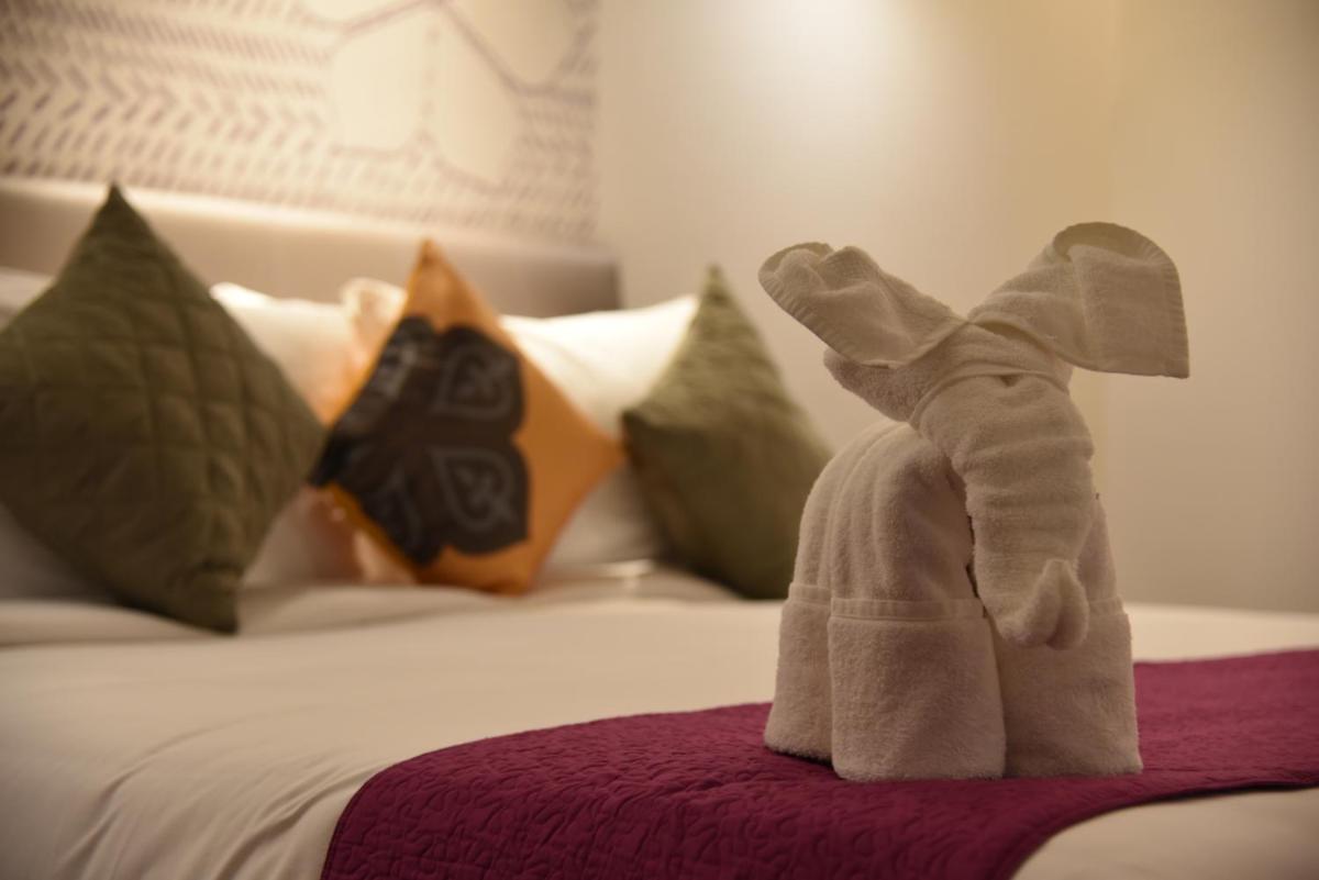 a stuffed elephant sitting on top of a bed at Grand Mercure Mysore - An Accor Brand in Mysore