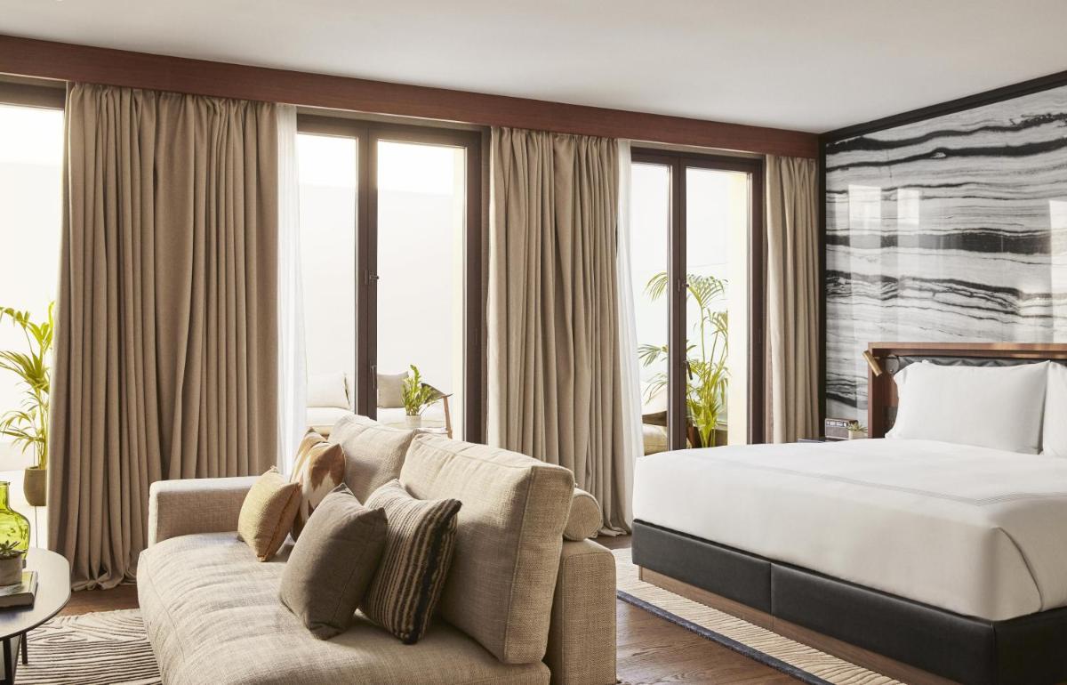 una habitación de hotel con una cama y un sofá en Thompson Madrid, by Hyatt, en Madrid una habitación de hotel con una cama y un sofá en Thompson Madrid, by Hyatt, en Madrid