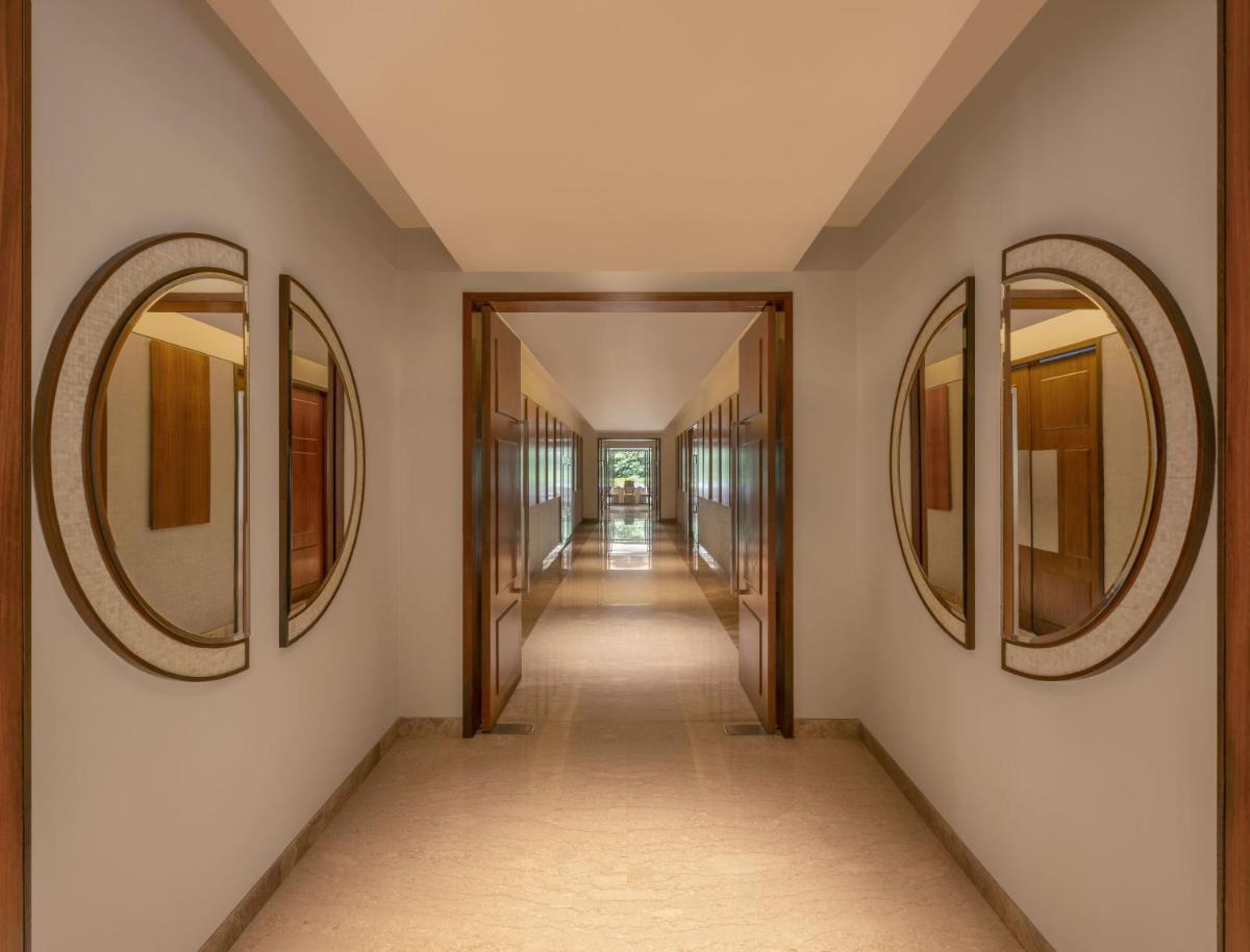 a hallway with three mirrors on the walls at The Raintree, St. Mary’s Road in Chennai