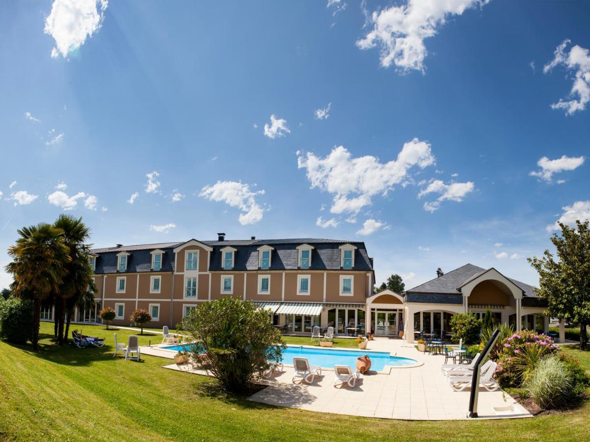 un complexe avec une piscine et un bâtiment dans l'établissement Alysson Hôtel, à Oloron-Sainte-Marie