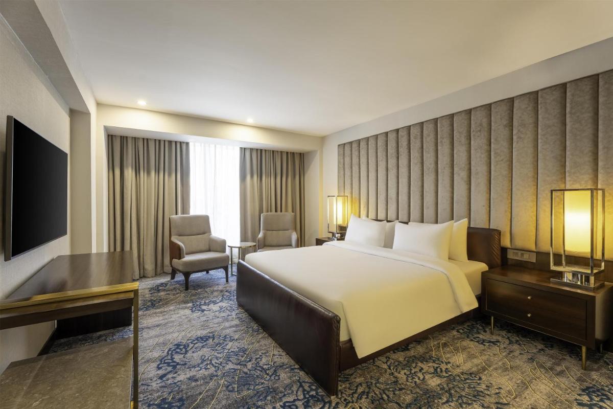 a hotel room with a bed and a desk at Radisson Blu Hotel Pune Kharadi in Pune