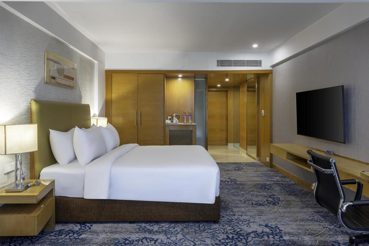 a hotel room with a bed and a television at Radisson Blu Hotel Pune Kharadi in Pune