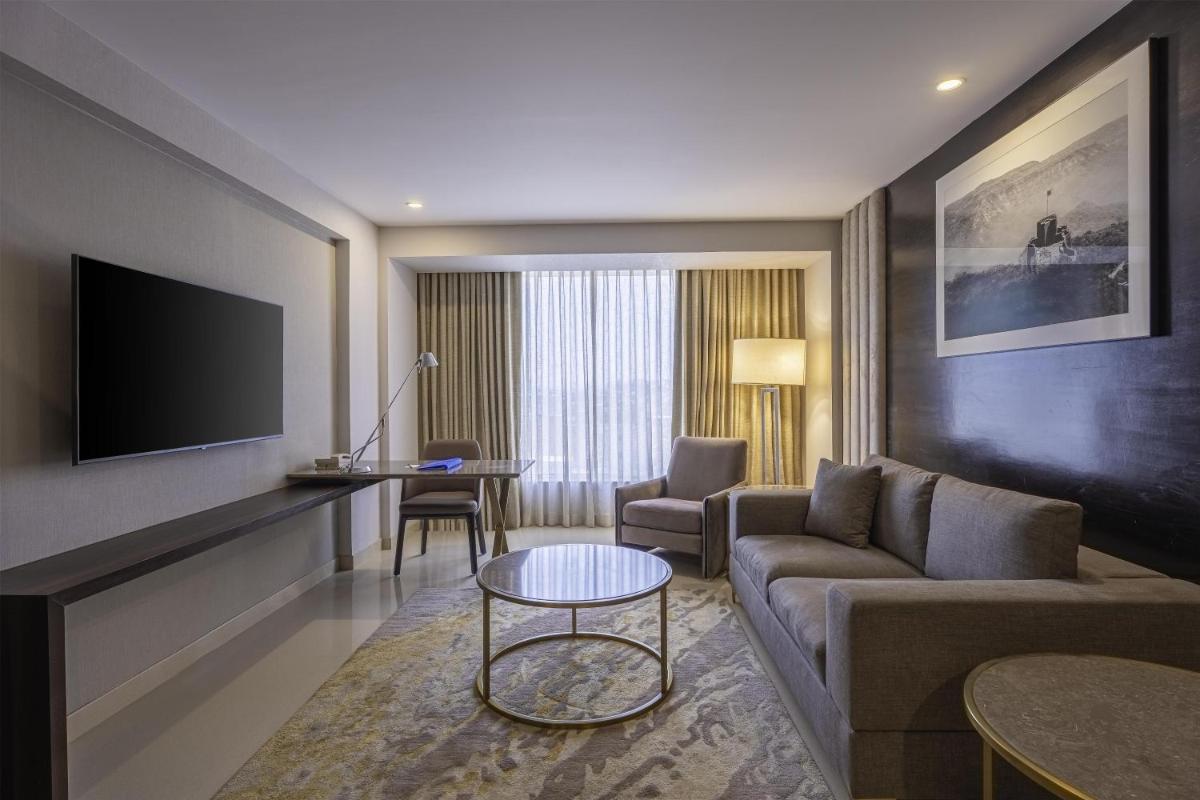 a living room with a couch and a tv at Radisson Blu Hotel Pune Kharadi in Pune