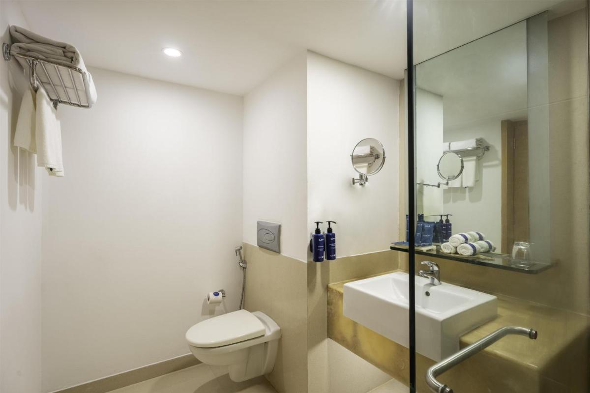 a bathroom with a toilet and a sink at Radisson Blu Hotel Pune Kharadi in Pune
