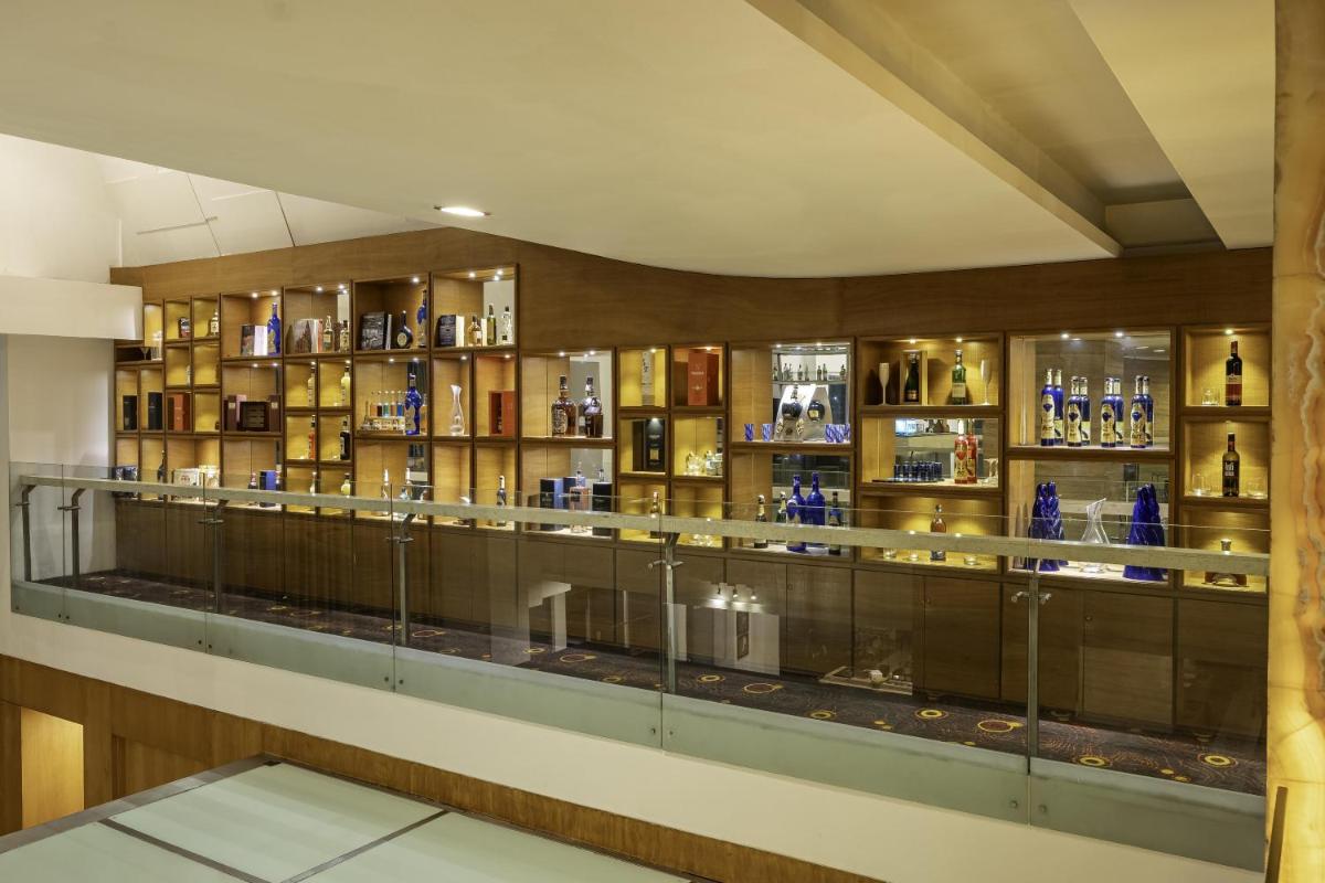a display case in a room with bottles of alcohol at Radisson Blu Hotel Pune Kharadi in Pune