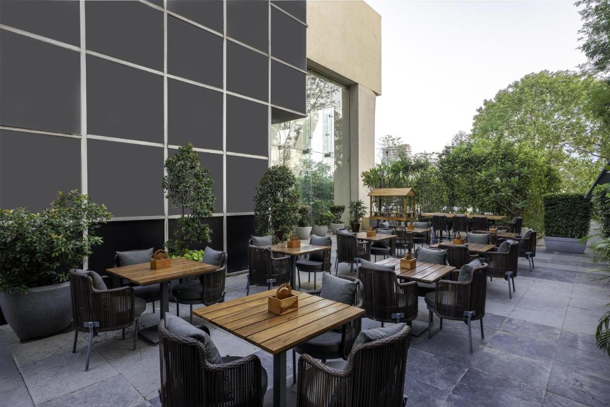 a restaurant with tables and chairs and a building at Radisson Blu Hotel Pune Kharadi in Pune