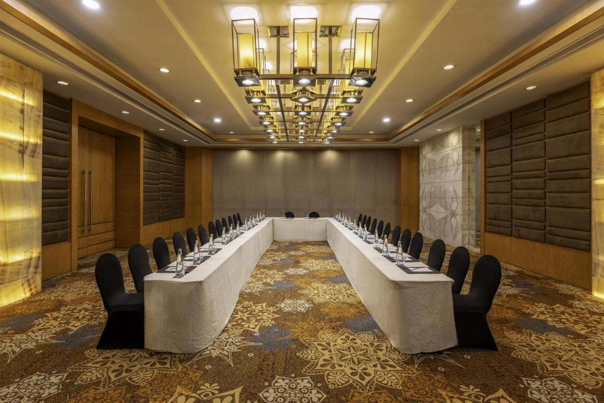 a conference room with a long table and chairs at Radisson Blu Hotel Pune Kharadi in Pune
