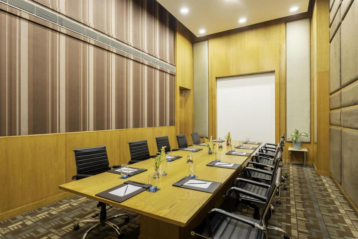 a conference room with a long table and chairs at Radisson Blu Hotel Pune Kharadi in Pune