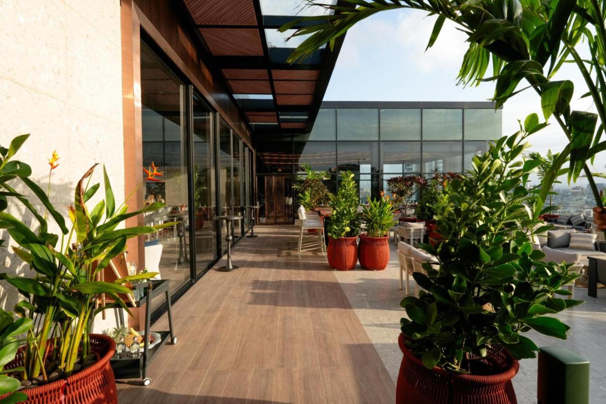 a lobby with potted plants in a building at Radisson Blu Hotel Pune Kharadi in Pune